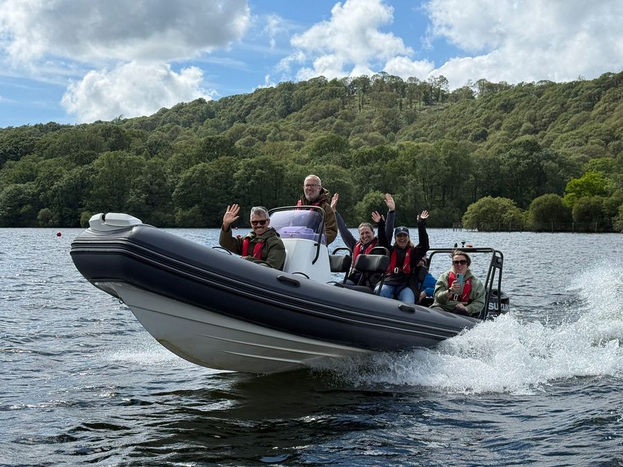 Ascend members waving from the boat on the lake
